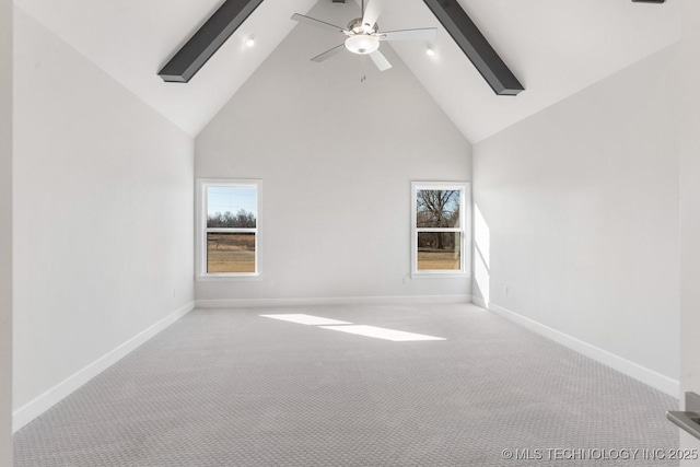 unfurnished room with high vaulted ceiling, a wealth of natural light, and baseboards