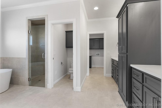 full bathroom featuring toilet, vanity, ornamental molding, a soaking tub, and a stall shower