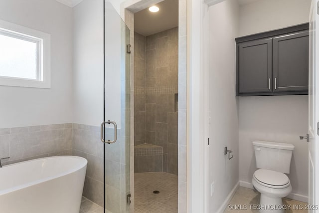 full bath with tile patterned flooring, toilet, baseboards, a freestanding bath, and a stall shower