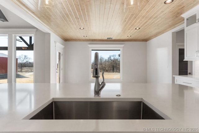 kitchen featuring wooden ceiling, light countertops, a sink, and recessed lighting