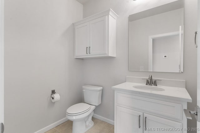 half bath with baseboards, vanity, toilet, and tile patterned floors