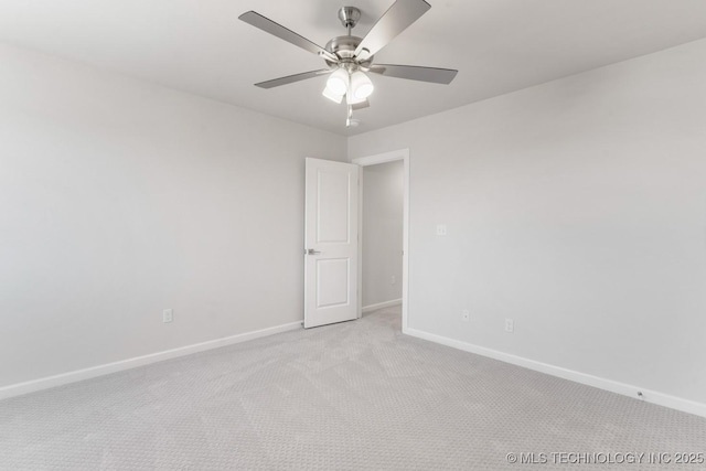 unfurnished room with a ceiling fan, light carpet, and baseboards