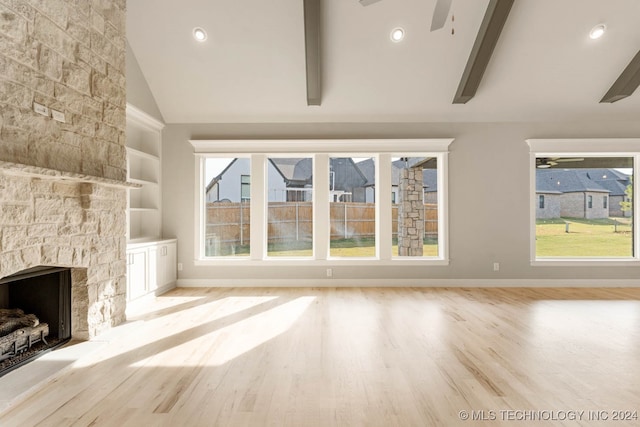 unfurnished living room with lofted ceiling with beams, light wood-type flooring, and a wealth of natural light