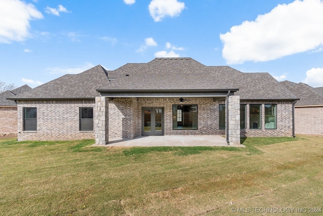 rear view of house featuring a lawn and a patio