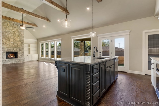 kitchen featuring ceiling fan, sink, beamed ceiling, dark hardwood / wood-style floors, and an island with sink