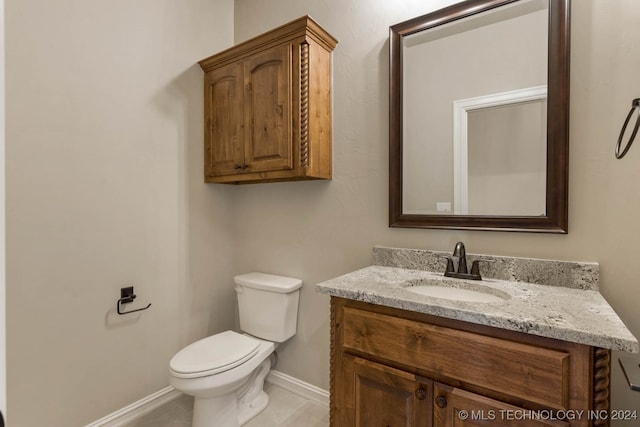 bathroom with tile patterned flooring, vanity, and toilet