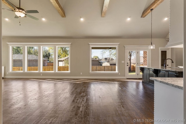 unfurnished living room featuring beam ceiling, ceiling fan, dark hardwood / wood-style flooring, and high vaulted ceiling