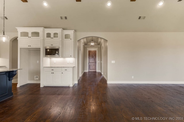 kitchen with light stone countertops, dark hardwood / wood-style flooring, and hanging light fixtures