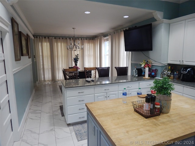 kitchen with an inviting chandelier, pendant lighting, white cabinets, and light tile floors