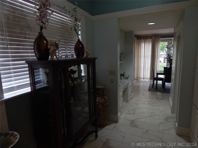 hall featuring tile flooring and ornamental molding