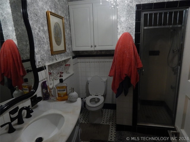 bathroom with tile walls, a shower with door, toilet, sink, and tile floors