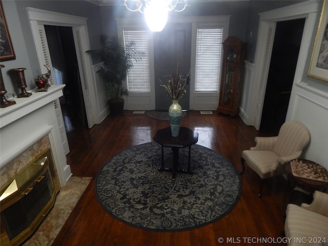 living room with a chandelier, a high end fireplace, and dark wood-type flooring