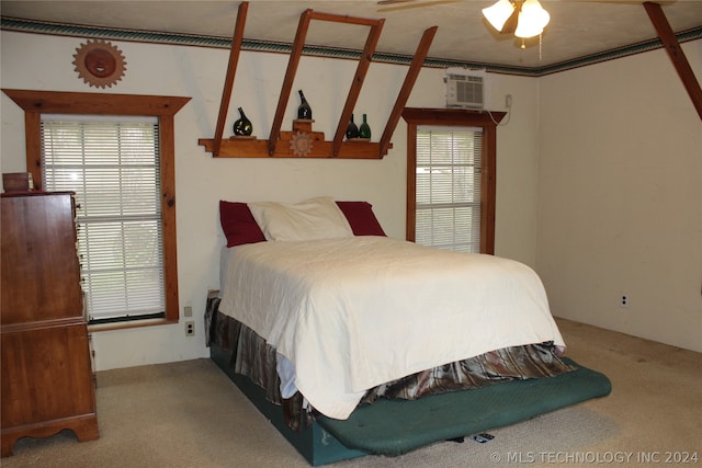 carpeted bedroom with ceiling fan and a wall mounted AC