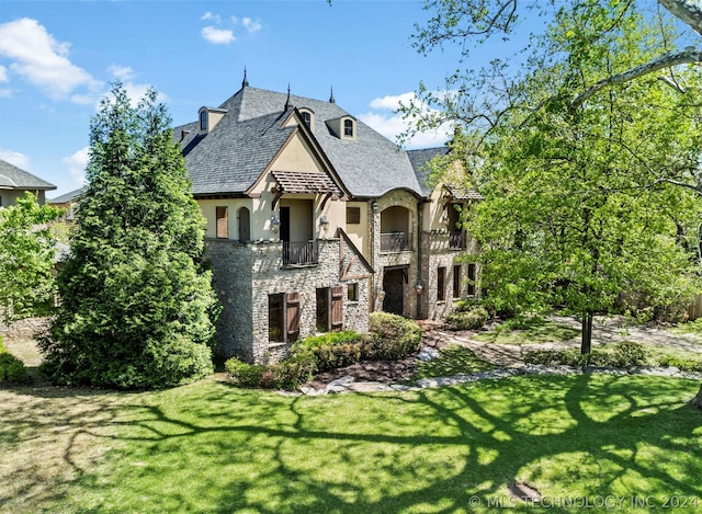 view of front of property with a front yard and a balcony