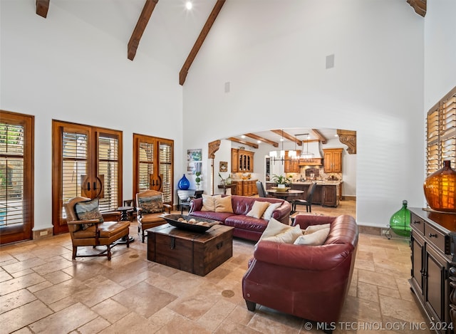 living room featuring beamed ceiling, a notable chandelier, and high vaulted ceiling