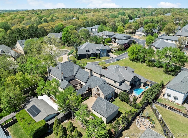 birds eye view of property featuring a wooded view and a residential view