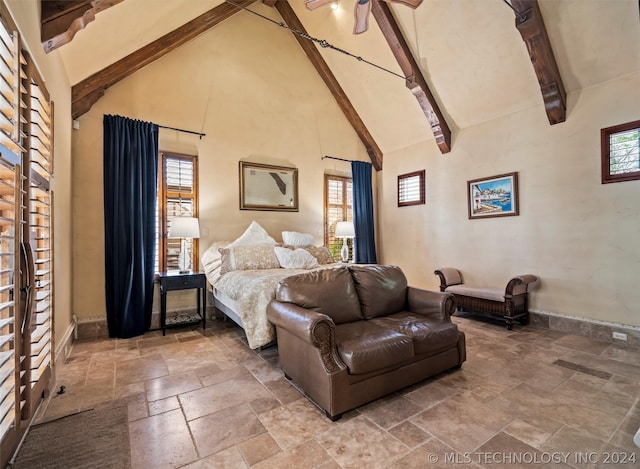 bedroom featuring multiple windows, high vaulted ceiling, and beamed ceiling