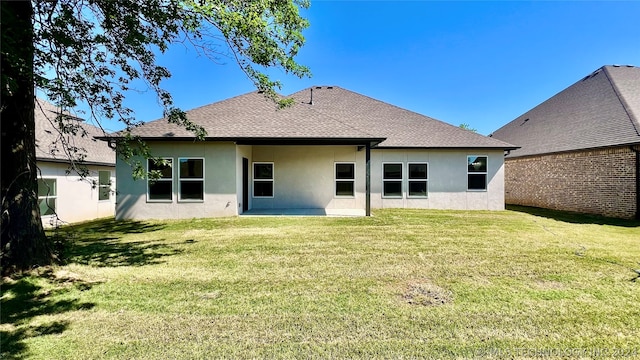 back of property with a yard and a patio area