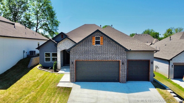 view of front of house featuring a garage, a front yard, and central air condition unit