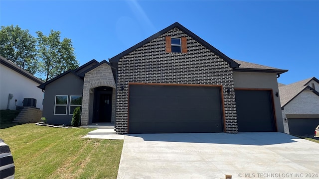 view of front of house with a garage, central AC unit, and a front lawn