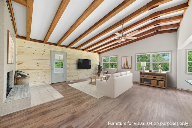 unfurnished living room with a wealth of natural light, lofted ceiling with beams, hardwood / wood-style flooring, and a fireplace