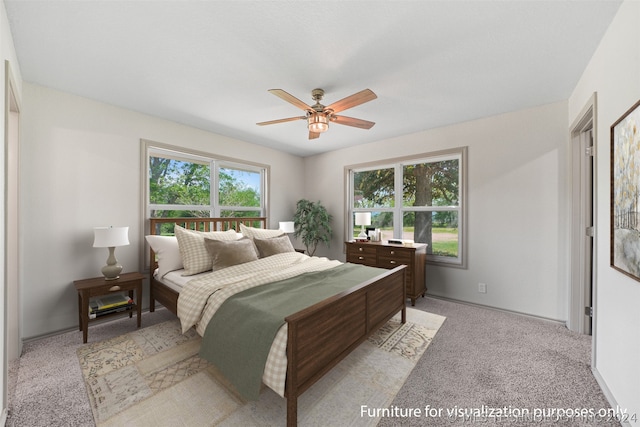 carpeted bedroom featuring multiple windows and ceiling fan