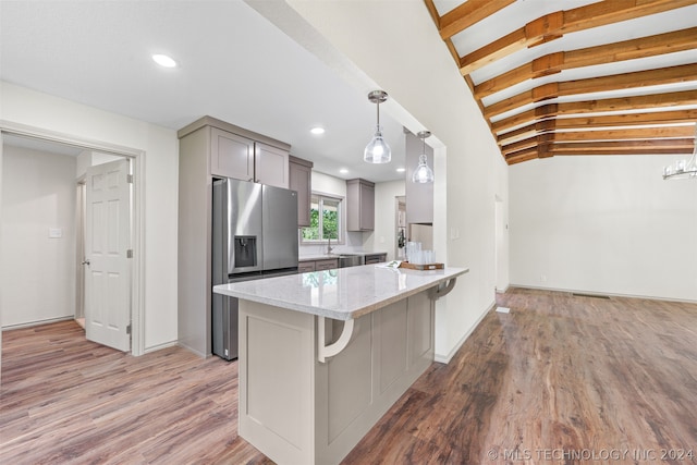 kitchen featuring light stone countertops, gray cabinetry, decorative light fixtures, wood-type flooring, and stainless steel refrigerator with ice dispenser