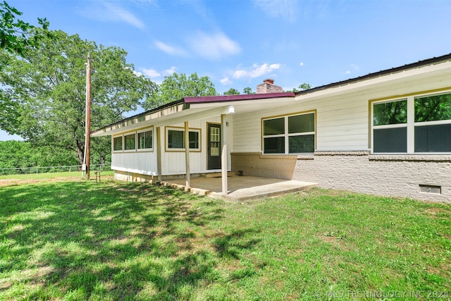 back of house featuring a patio and a lawn