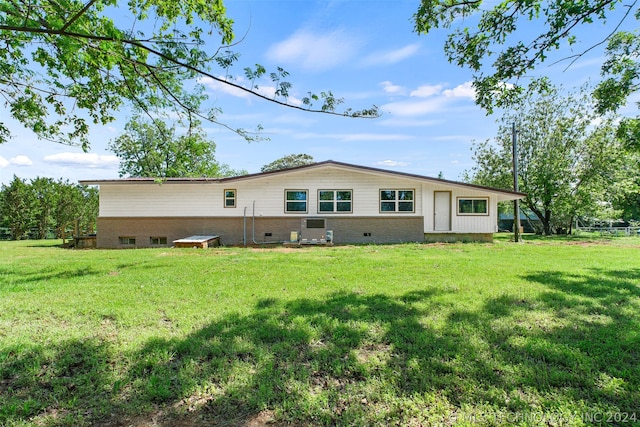 rear view of house featuring a yard