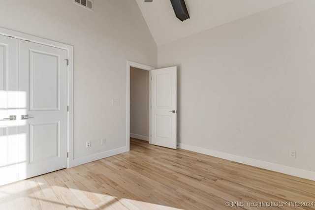 unfurnished bedroom with a closet, light hardwood / wood-style floors, high vaulted ceiling, and ceiling fan