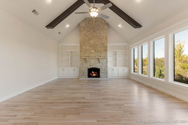 unfurnished living room featuring built in shelves, ceiling fan, high vaulted ceiling, a fireplace, and light wood-type flooring