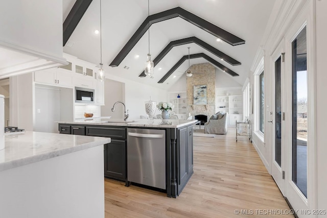 kitchen featuring decorative light fixtures, white cabinetry, an island with sink, sink, and stainless steel dishwasher