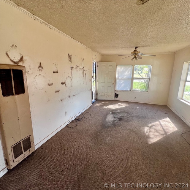 unfurnished room featuring ceiling fan, a textured ceiling, and carpet flooring