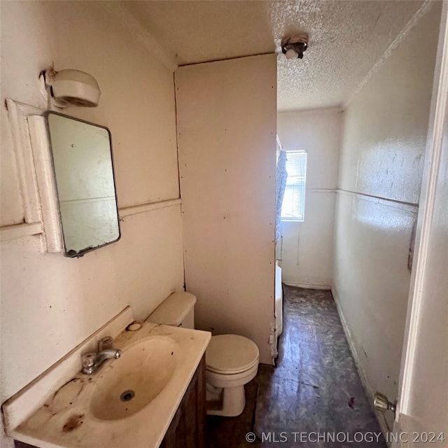 bathroom featuring a textured ceiling, vanity, and toilet