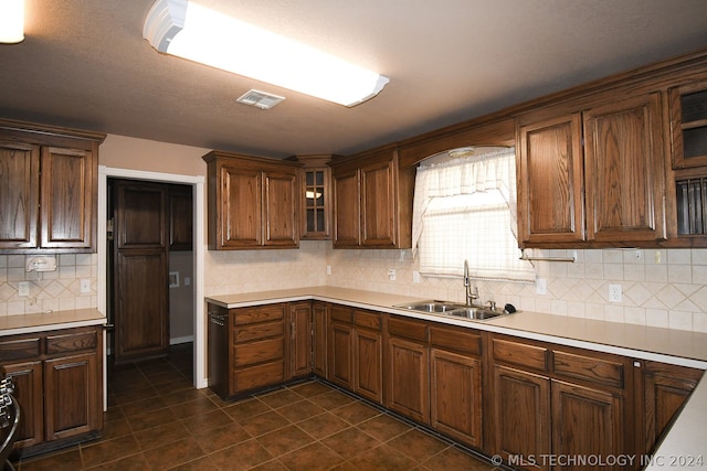 kitchen with dark tile flooring, sink, and backsplash