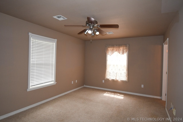 carpeted spare room with plenty of natural light and ceiling fan