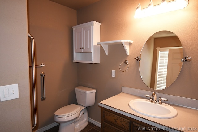 bathroom featuring tile flooring, toilet, and vanity