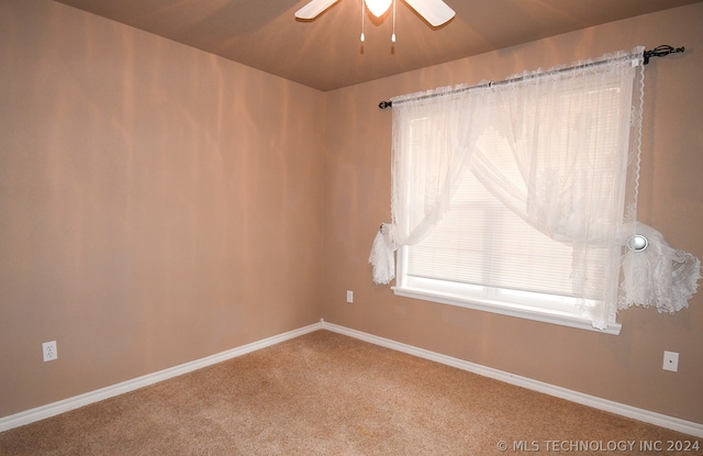 spare room featuring carpet and ceiling fan