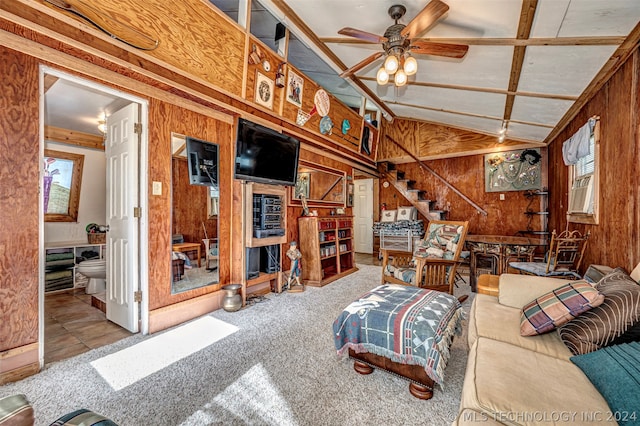 living room featuring a healthy amount of sunlight, wooden walls, and ceiling fan