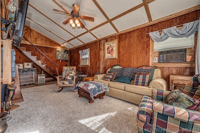 carpeted living room with vaulted ceiling, wooden walls, and ceiling fan