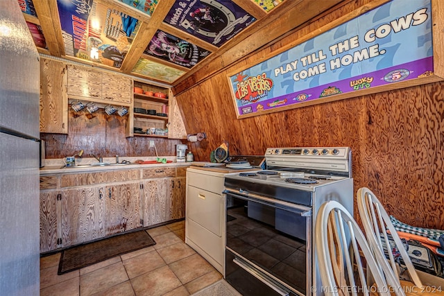 kitchen featuring light tile floors, sink, wooden walls, and range with electric stovetop