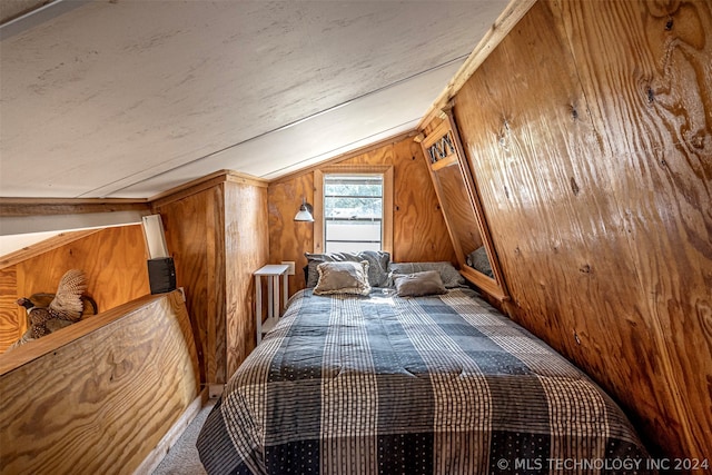 unfurnished bedroom featuring wood walls, carpet floors, and lofted ceiling