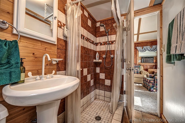 bathroom featuring wood walls, sink, tile flooring, and a shower with shower curtain