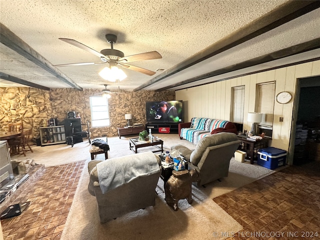 carpeted living room featuring ceiling fan and a textured ceiling