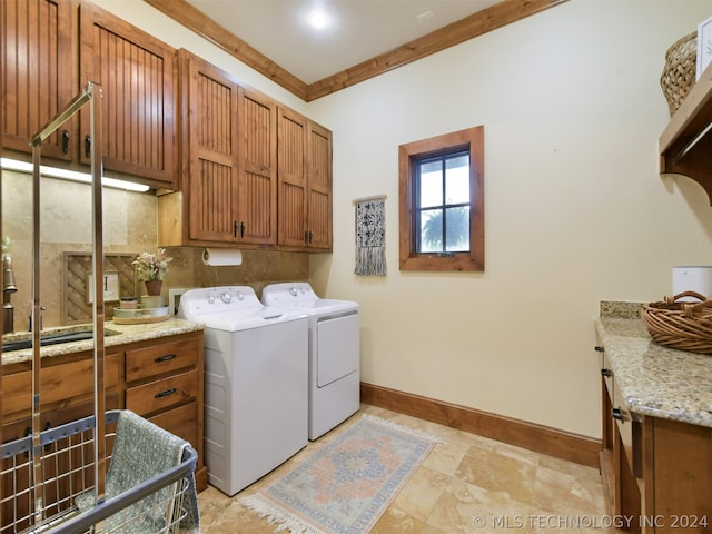 laundry area featuring cabinets, washer and clothes dryer, ornamental molding, and sink