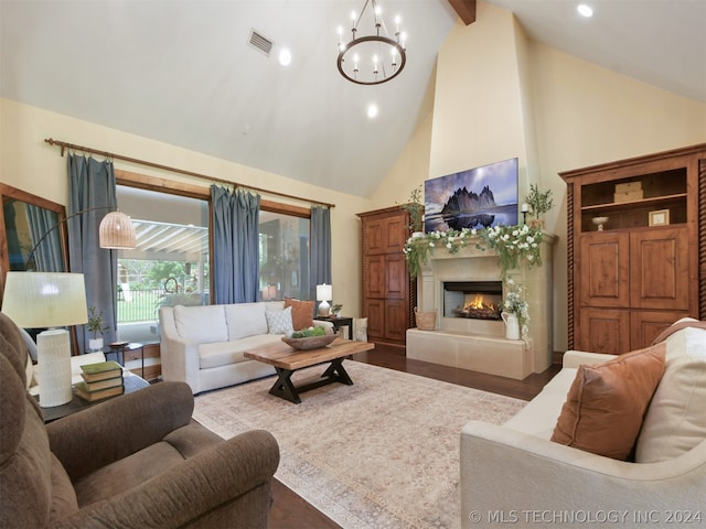 living room with beam ceiling, an inviting chandelier, high vaulted ceiling, hardwood / wood-style floors, and a tiled fireplace