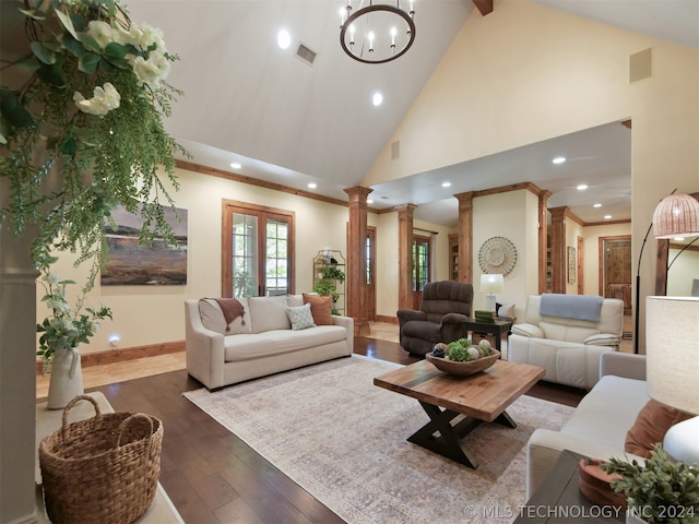 living room featuring ornate columns, high vaulted ceiling, dark hardwood / wood-style floors, and a notable chandelier