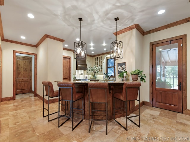 kitchen with kitchen peninsula, a breakfast bar, hanging light fixtures, and ornamental molding