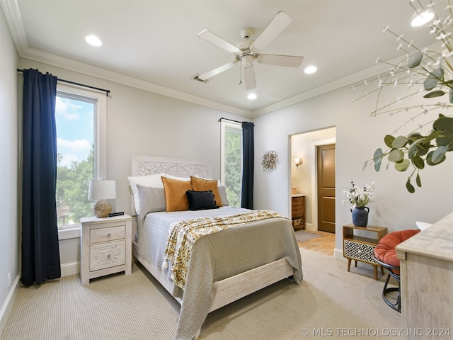 bedroom featuring connected bathroom, light colored carpet, ceiling fan, and ornamental molding