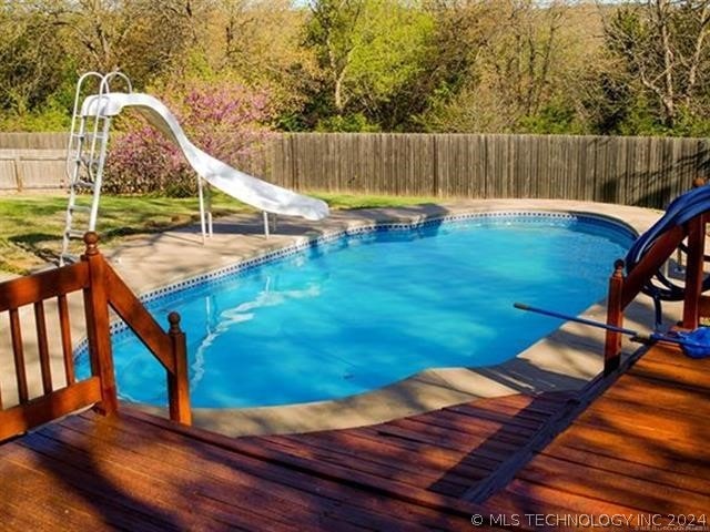 view of pool featuring a deck and a water slide